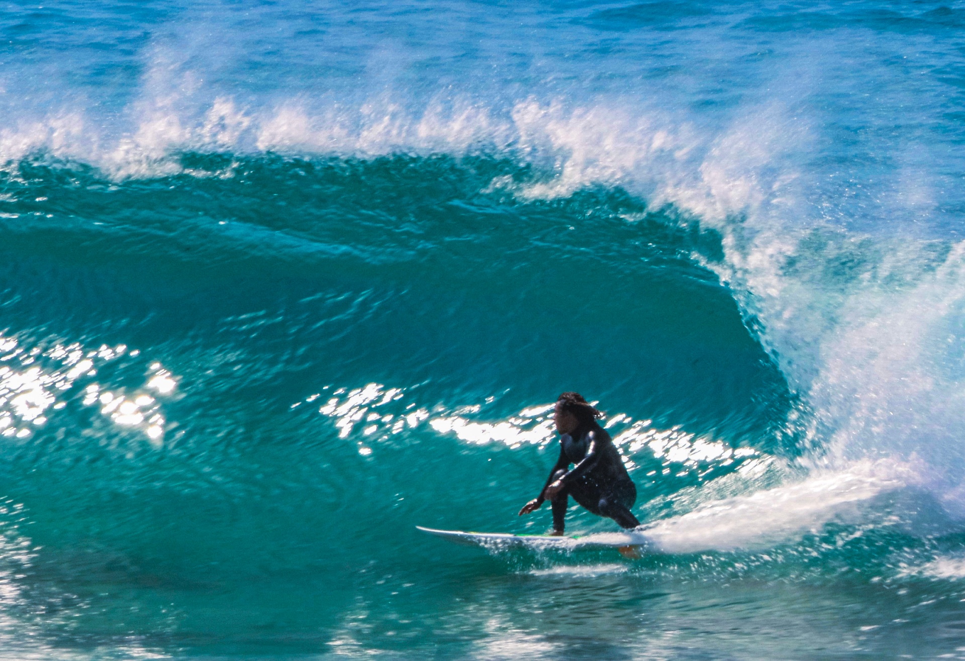 Surfer tucked inside a glassy turquoise barrel on the Pacific coast