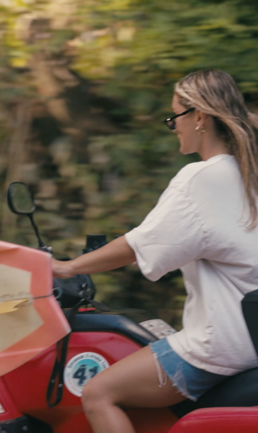 Guest cruising a red ATV down a jungle back road on a Beach Boys day trip